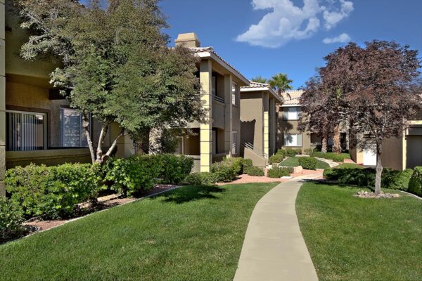 San Croix apartments with lush landscaping, tall trees, paved walkways, and green lawns.