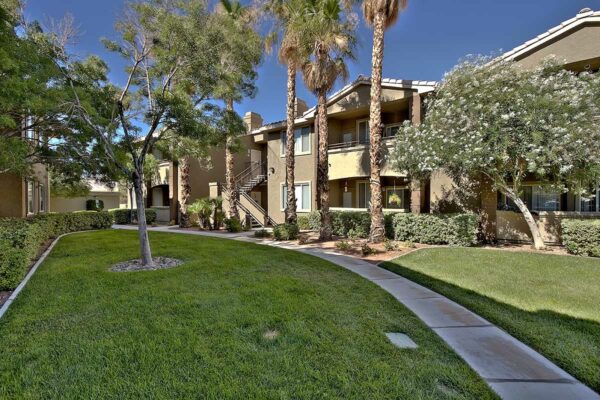 San Croix apartments with lush landscaping, tall trees, paved walkways, and green lawns.