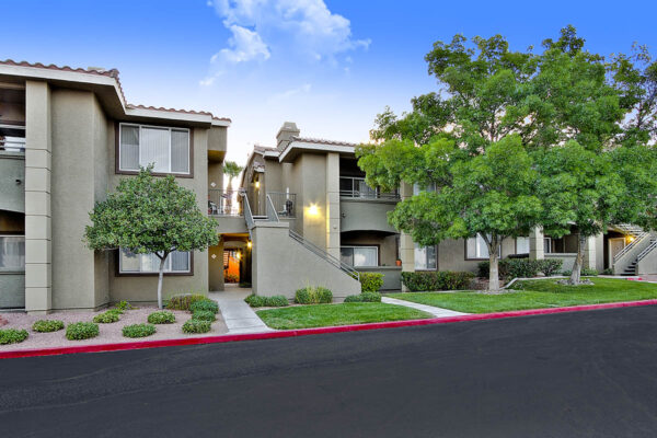 San Croix apartments with lush lawns, rocky landscaping, and tall trees.