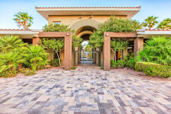 San Croix clubhouse with stone paver patio, lush landscaping, and elegant archways.