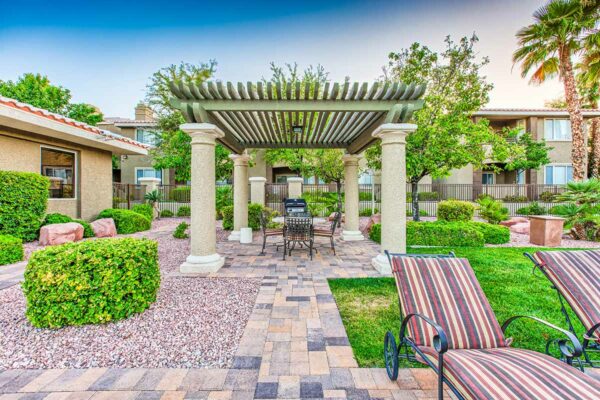 Outdoor gazebo with stone paver patio, dining table, and built in BBQ grill.