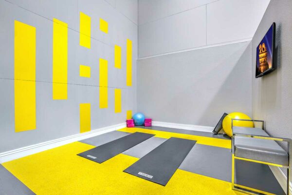 Fitness center with colorful accents, yoga equipment, and TV.