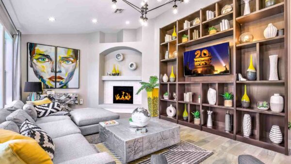 Clubroom with plush couch, fireplace, shelves with decor and TV, and large artwork.