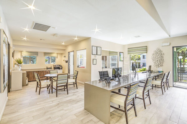 Business center with computer desks, office table with chairs, and leasing office.