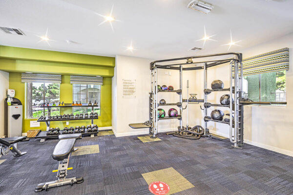 Fitness center with weight equipment and large windows.