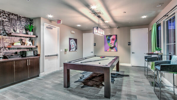 Lounge with pool table, bar table with stools, demo kitchen, and pop artwork.