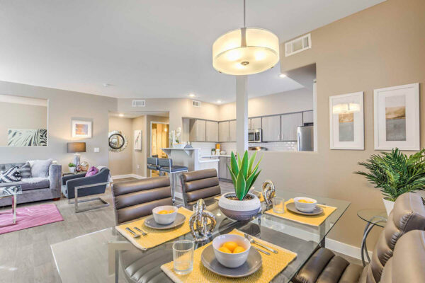 Large living area in apartment in Summerlin with wood floors, modern kitchen and dining area, and comfortable seating area.