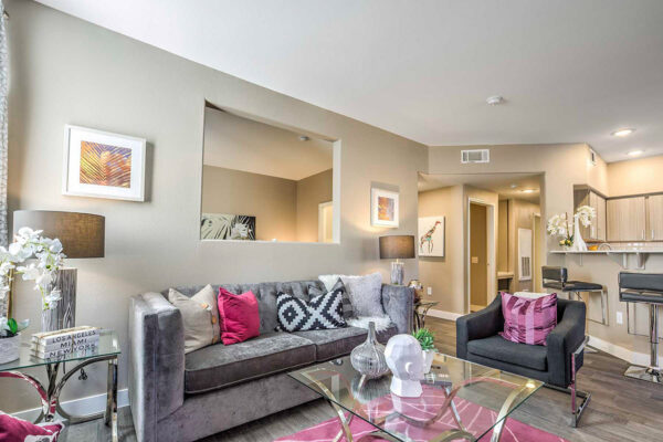 Living room with wood floor, plush seating, eclectic decor, TV, and breakfast bar.