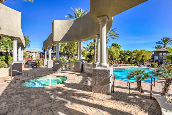 Pool area with stone paver patio and elevated terrace with spa.