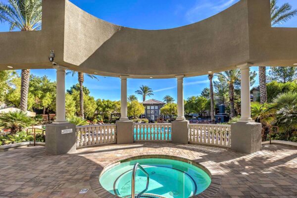Pool area with stone paver patio and elevated terrace with spa.