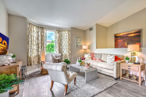 airy living room in spcaious Summerlin nevada apartment with floor to ceiling windows, couch and chairs