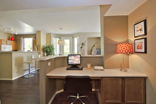 Built-in desk or office nook separating the living area from the kitchen bar.
