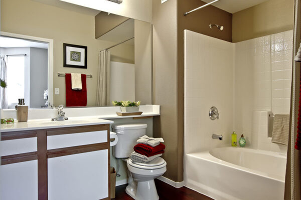 Bathroom with a tub, shower, and a light wood vanity with a white countertop.