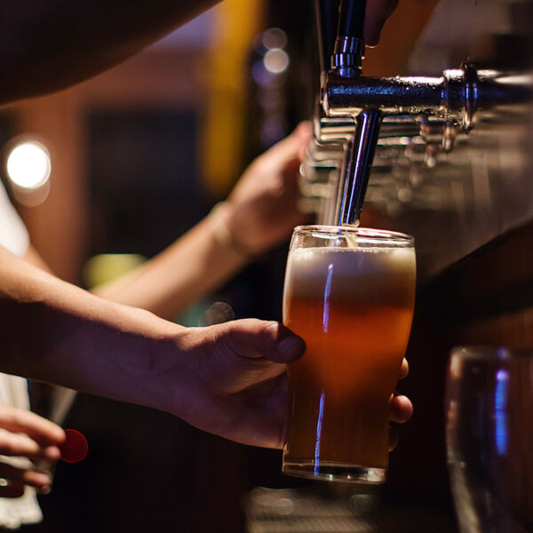 Person pouring beer from tap.