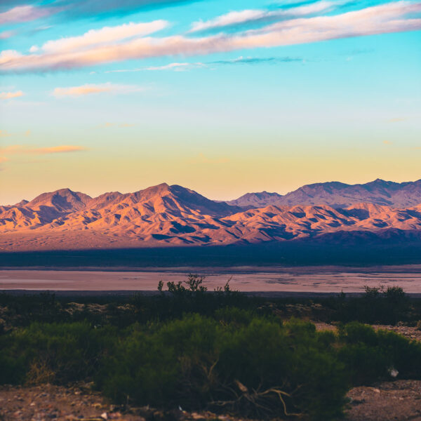 Sunrise over mountains surrounding Las Vegas with cloudy skies.
