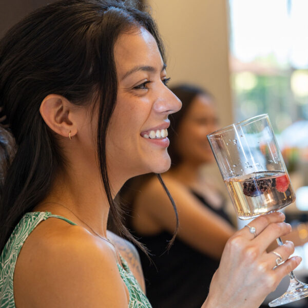 Person with champagne and fruit in wine glass.