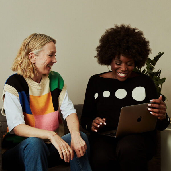 Older people laughing together looking at laptop.