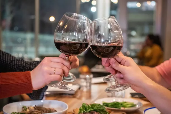 Friends at dinner toasting with wine glasses.