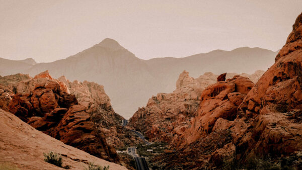 Paved highway winding through towering red rocks.