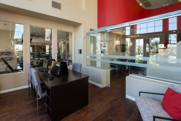 Arzano apartments business center with computer desks and glass walls.