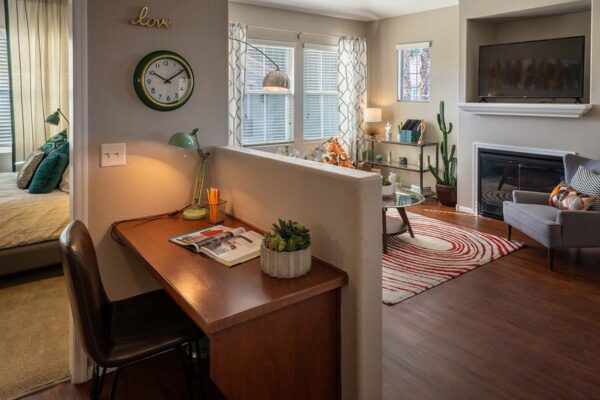Arzano apartment living room with wood style floor, built in desk, fireplace, and large windows.