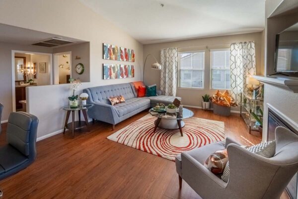 Arzano apartment living room with wood style floor, pattern rug, plush sectional, and large windows.
