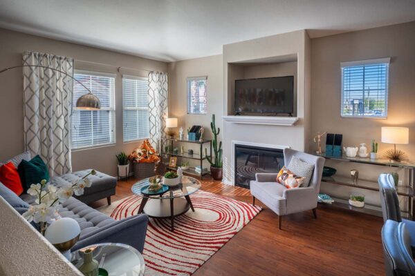 Arzano apartment living room with wood style floor, fireplace, TV, plush sectional, and large window.