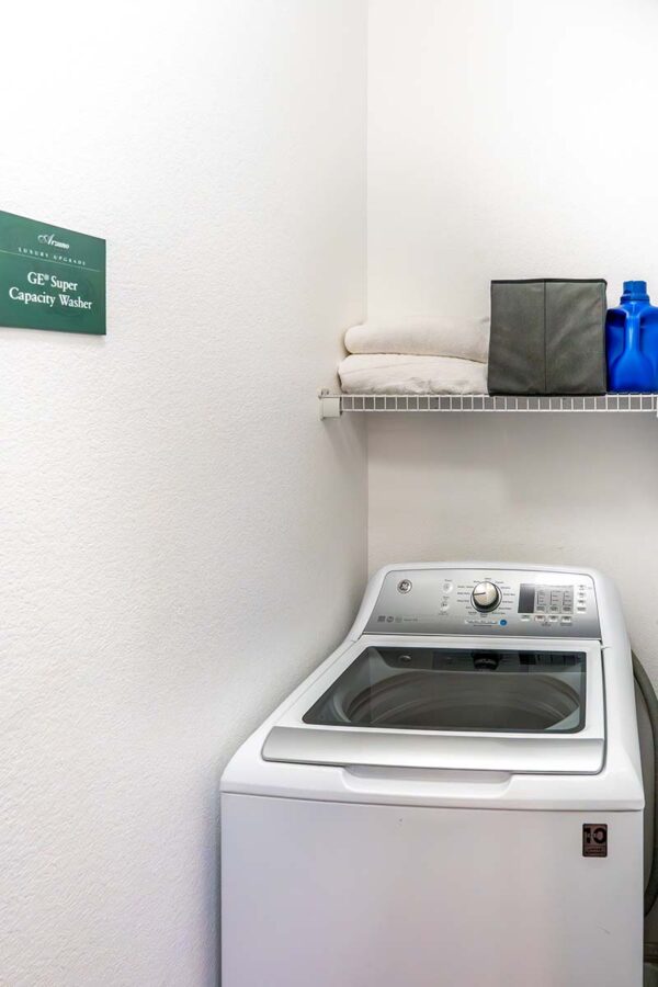 Arzano apartment living room with washing machine and built in wire shelves.