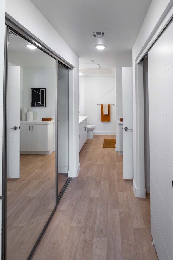 Arzano apartment hallway with wood style floor and closet doors.