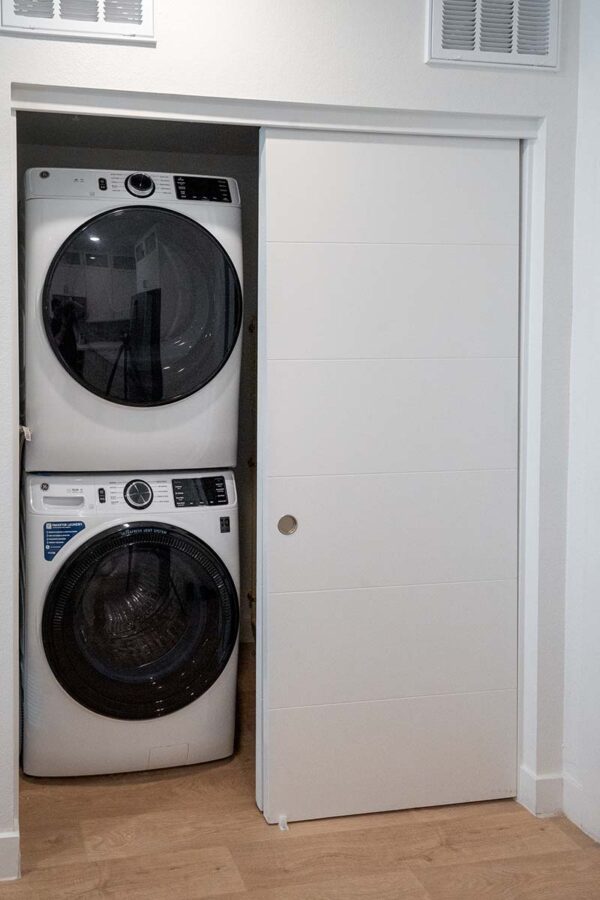 Arzano apartment laundry closet with stacked washer and dryer.